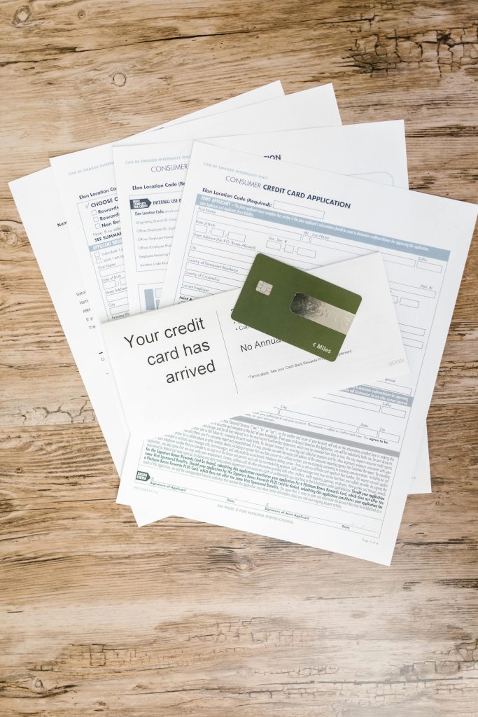 pexels-photo-7821465-7821465 Top view of credit card with application forms and letter on a wooden desk.