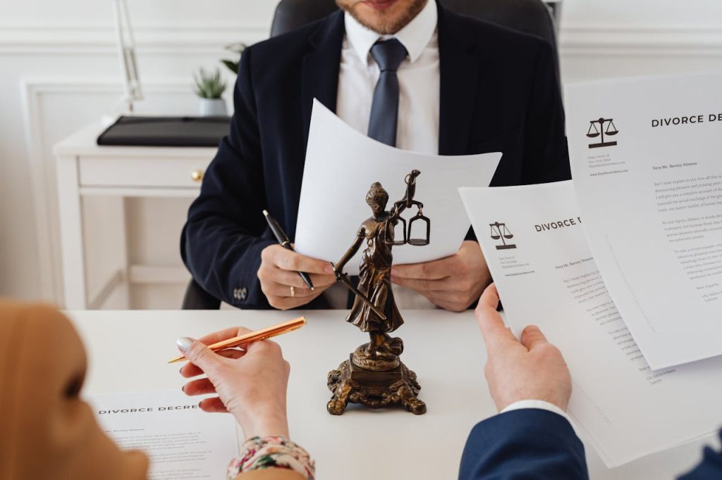 pexels-photo-7876050 Legal professionals reviewing divorce documents in a law office with a Lady Justice statue.